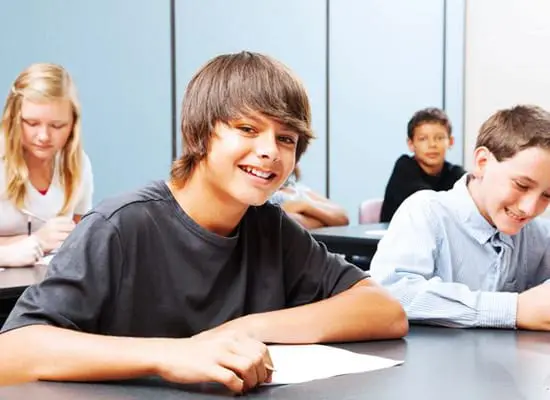 A group of young people sitting at tables.